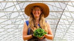 Kat the farmer in greenhouse holding lettuce